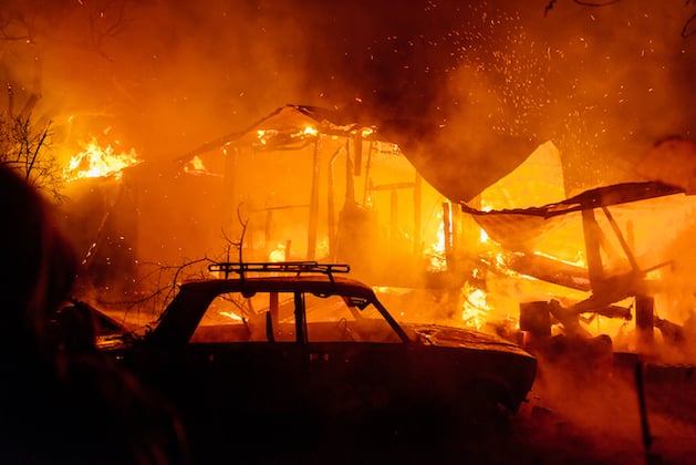 house-fire-at-night-with-burnt-car-in-smoke
